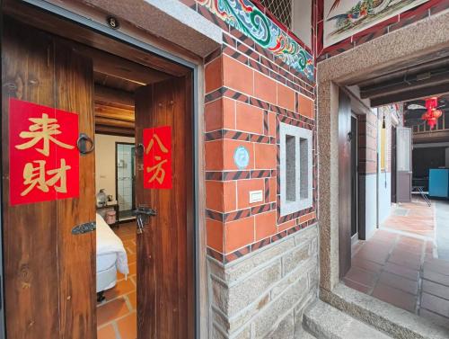 a brick building with two red signs on the door at 湖峰古厝民宿 in Jinning