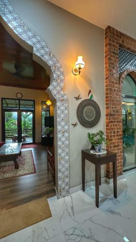 a living room with a table and a brick wall at The Manzil Janda Baik in Bentong