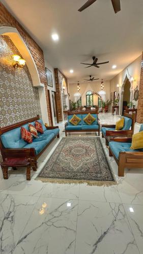 a living room with blue couches and a rug at The Manzil Janda Baik in Bentong