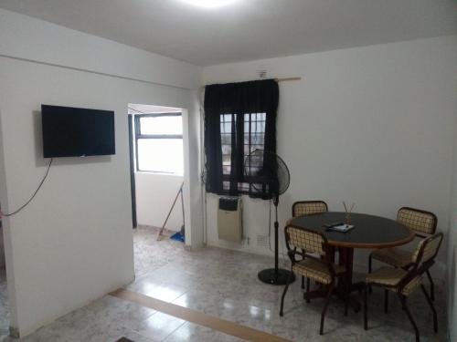 a dining room with a table and chairs and a television at Departamento céntrico in Concepción del Uruguay