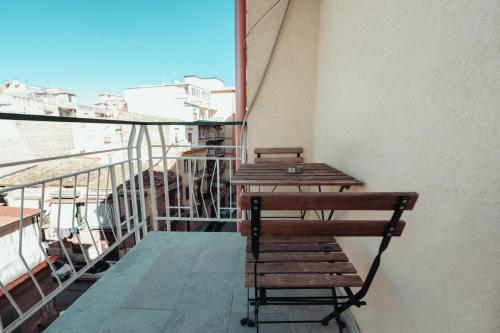 a balcony with a wooden table and chairs on a building at Central Room 128L in Palermo