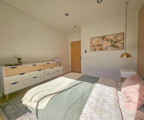 a bedroom with a large bed and a dresser at Brimfield Stay in Los Angeles