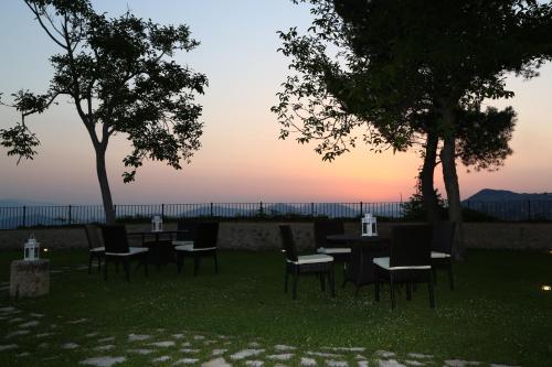 a group of tables and chairs with the sunset in the background at Monastero Di Sant'Erasmo in Veroli