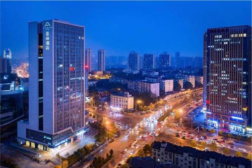 長沙市にあるAtour Hotel Changsha Xiyingmen Fanchengの夜の高層ビルが立ち並ぶ街のスカイライン