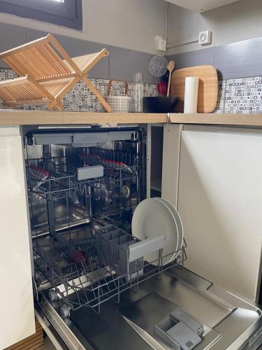 a dishwasher with dishes in it in a kitchen at SPA Relax 3 chambres in Saint-Joseph