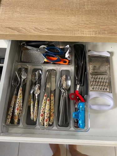 a drawer filled with utensils in a cabinet at SPA Relax 3 chambres in Saint-Joseph