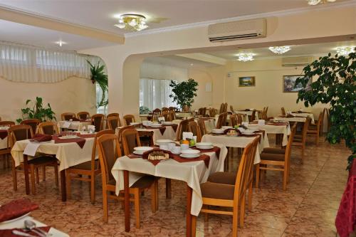 ein Restaurant mit Tischen und Stühlen in einem Zimmer in der Unterkunft Edem Pansionat in Sochi
