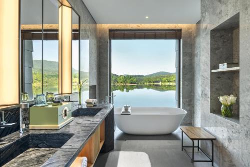a bathroom with a tub and a view of a lake at 紫云玄清酒店 ZiYunXuanQing Resort&Spa 