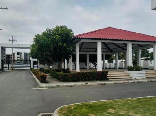 a pavilion with a red roof in a parking lot at Hermosa casa en Flandes in Flandes