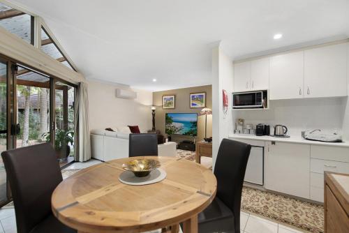 a kitchen and dining room with a wooden table and chairs at Villa 3 By The Sea in Coffs Harbour