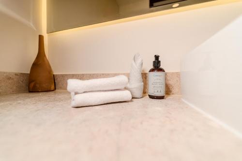 a bathroom with towels and a bottle of wine at Luxury Jungle Condos by Casago in Tulum