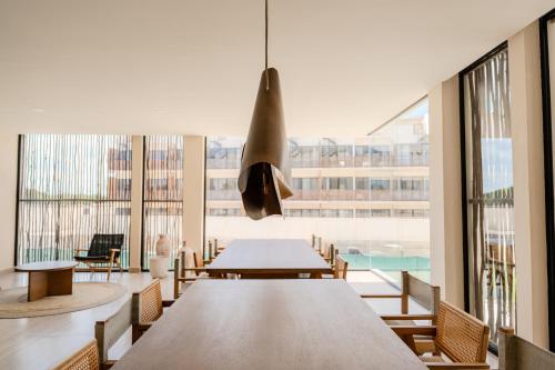 a dining room with a table and chairs and windows at Luxury Jungle Condos by Casago in Tulum