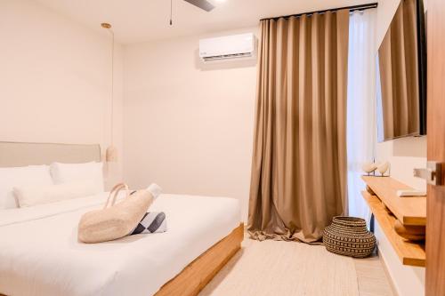 a hotel room with a bed with a towel on it at Luxury Jungle Condos by Casago in Tulum