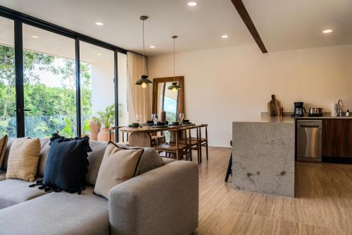 a living room with a couch and a kitchen at Luxury Jungle Condos by Casago in Tulum