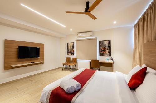 a bedroom with a bed and a desk and a tv at Maple Comfort in Visakhapatnam
