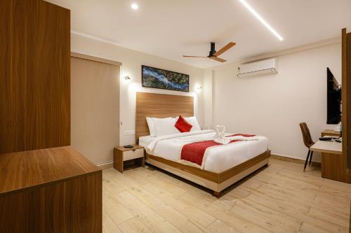 a bedroom with a bed and a desk and a television at Maple Comfort in Visakhapatnam