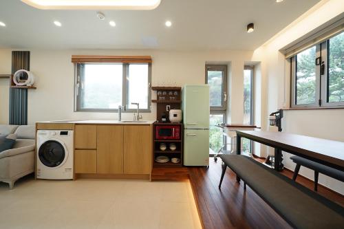 a kitchen with a sink and a refrigerator in a room at Gyeongju Poolvilla Runtoyou in Gyeongju