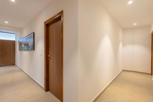 an empty hallway with a wooden door and a hallway at Maple Comfort in Visakhapatnam