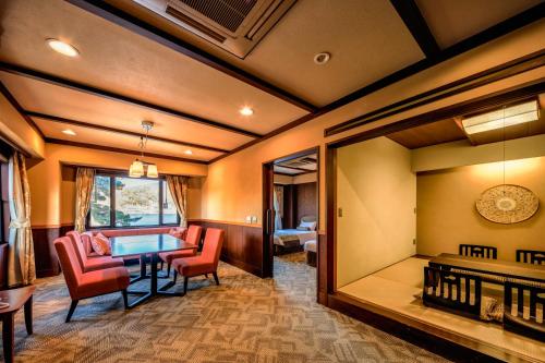 a dining room with a table and red chairs at Fuji Lake Hotel in Fujikawaguchiko