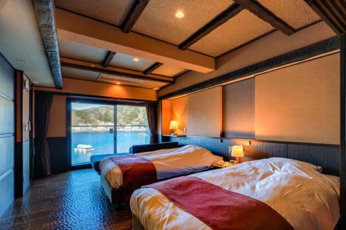 a hotel room with two beds and a window at Fuji Lake Hotel in Fujikawaguchiko