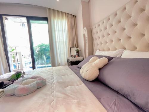 sypialnia z dużym łóżkiem z dwoma pluszakami w obiekcie Venetian Signature Condo Pattaya w mieście Jomtien Beach