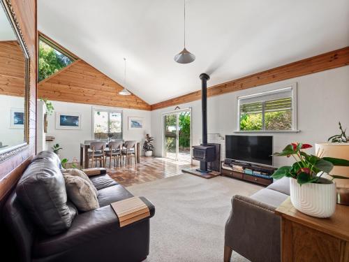 a living room with a leather couch and a television at Ryma Cottage - Prevelly NEW in Prevelly