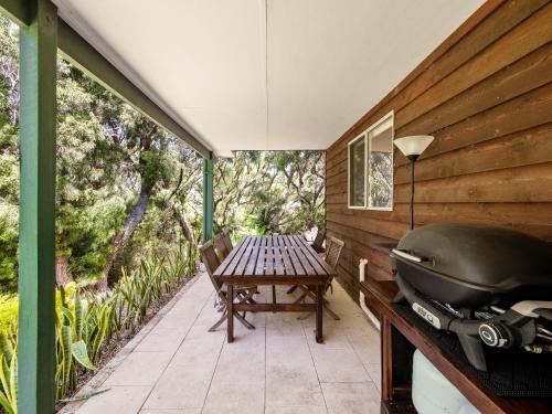an outdoor patio with a grill and a table at Ryma Cottage - Prevelly NEW in Prevelly