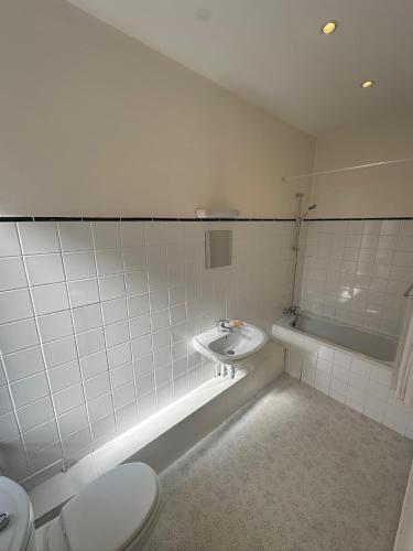 a bathroom with a toilet and a sink and a tub at Hotel de Trois St Gervais in Saint-Gervais-les-Bains
