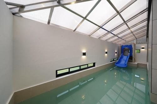 a swimming pool with a slide in a building at Gyeongju Poolvilla Runtoyou in Gyeongju