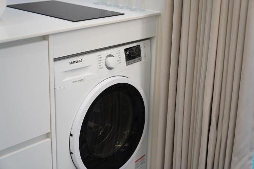 a white washing machine in a kitchen next to a counter at Gyeongju Poolvilla Runtoyou in Gyeongju