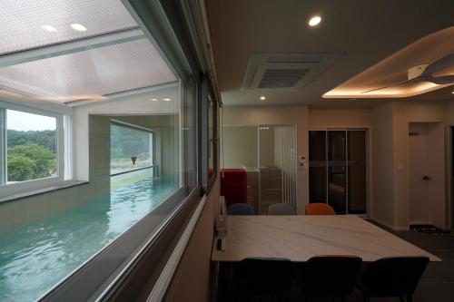 a room with a table and a swimming pool at Gyeongju Poolvilla Runtoyou in Gyeongju