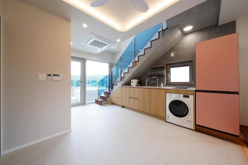 a laundry room with a washer and dryer and a staircase at Gyeongju Poolvilla Runtoyou in Gyeongju