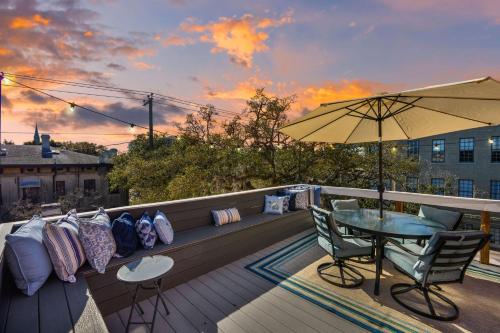 a balcony with a table and chairs and an umbrella at Penthouse! Rooftop Deck Movie Room Walkable-4 in Savannah