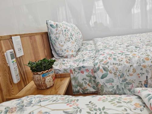 a bedroom with two beds and a plant on a table at Căn Hộ 4 PN Rin's House Homestay in Phan Thiet