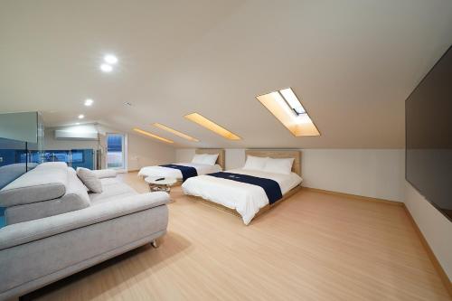 a large bedroom with two beds and a couch at Gyeongju Poolvilla Runtoyou in Gyeongju