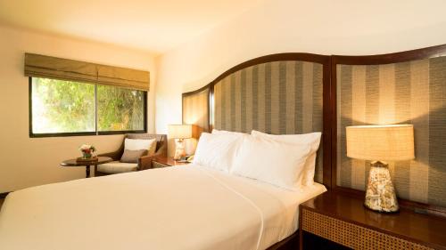 a hotel room with a bed and a chair at Club Agutaya in San Vicente