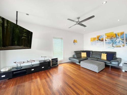 Una sala de estar con un sofá y un televisor de pantalla plana. en Heart of the Village - Walk to the Waters Edge, en Shellharbour