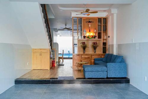 a living room with a blue couch and a table at Căn Hộ 4 PN Rin's House Homestay in Phan Thiet