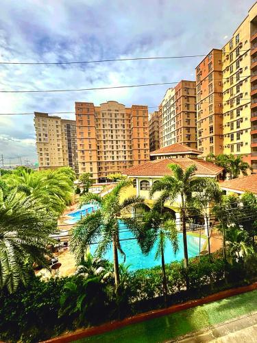 a view of a resort with a pool and palm trees at Avida Condo near NAIA in Manila