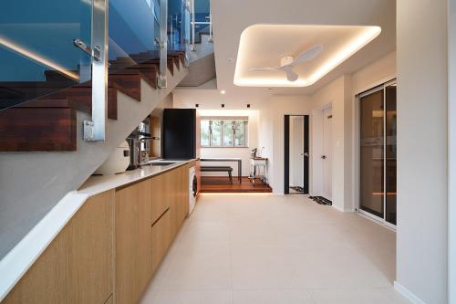a kitchen with wooden cabinets and a staircase at Gyeongju Poolvilla Runtoyou in Gyeongju