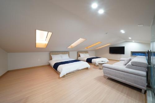 a bedroom with a bed and a couch and a tv at Gyeongju Poolvilla Runtoyou in Gyeongju