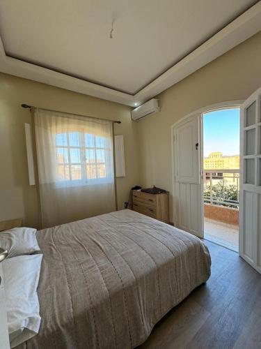 a bedroom with a bed and a large window at very nice house in Marrakech