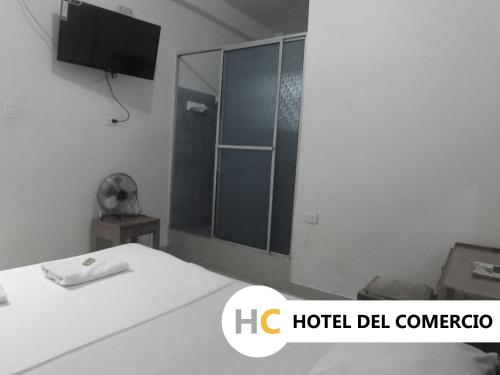 a bathroom with a shower and a bed in a room at Hotel del Comercio in Villavicencio