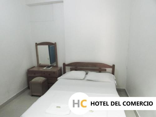 a small bedroom with a bed and a mirror at Hotel del Comercio in Villavicencio