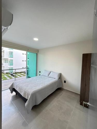 a bedroom with a bed and a large window at Depa Nuevo Acapulco Diamante in Acapulco