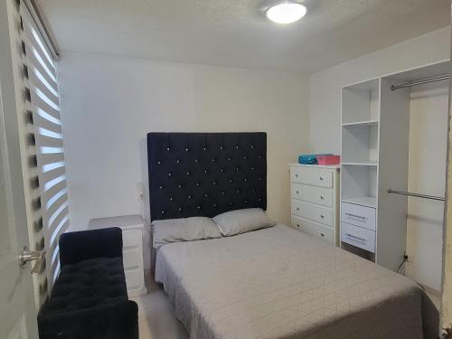 a small bedroom with a bed and a chair at Aguilas Room 1 in Guadalajara