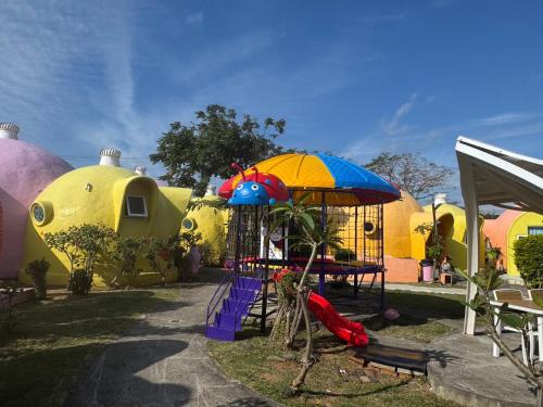 a group of play structures with umbrellas and a playground at Kenting Ha-Bi Star Fort in Hengchun