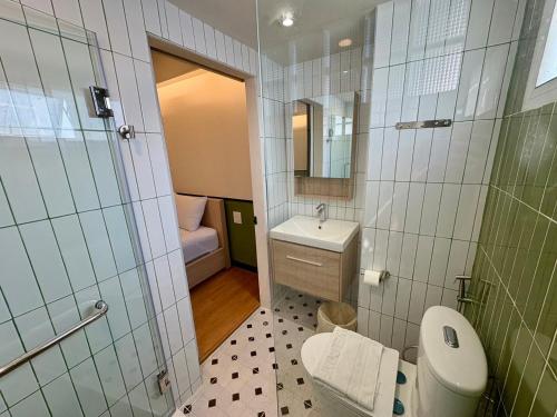 a small bathroom with a toilet and a sink at U Sabai Hotel Bangkok in Bangkok