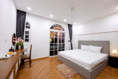 a bedroom with a bed and a desk and a window at Sun'House- Family 2BR Apt View Sea & Sunset Town Phu Quoc in Phu Quoc