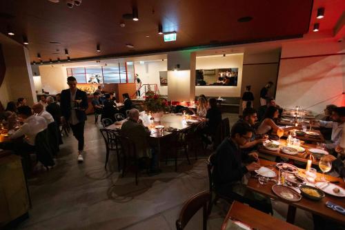 a group of people sitting at tables in a restaurant at Hotel Indigo Sydney Potts Point by IHG in Sydney
